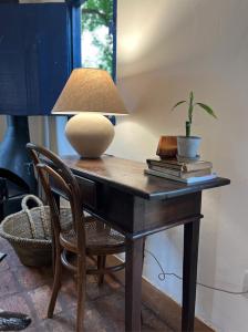 uma mesa com uma lâmpada e uma planta sobre ela em Hospedaria do Feno em Brotas