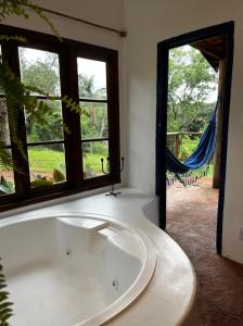a bath tub in a room with a window at Hospedaria do Feno in Brotas