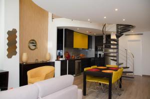 a kitchen and living room with a table and yellow chairs at Porto Náutico & Spa in Porto