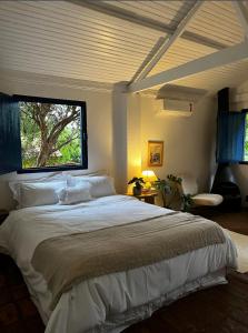 a bedroom with a large bed with a window at Hospedaria do Feno in Brotas