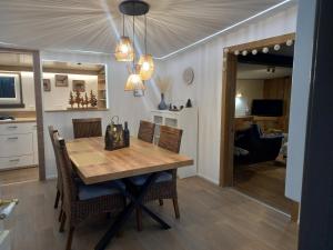 a kitchen and dining room with a wooden table and chairs at Le chalet du lac in Robertville