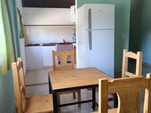 a kitchen with a table and chairs and a refrigerator at Cabaña El Apicultor in Cachí