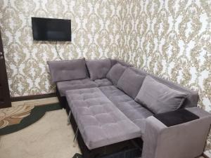 un sofá en una sala de estar con TV en one-room apartment in Dushanbe en Dushanbe