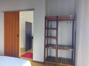 a room with a book shelf next to a bed at Recanto Berlin in Prado