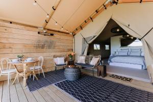 Villas & Vines Glamping في هاستينغز: غرفة نوم في خيمة مع سرير وطاولة