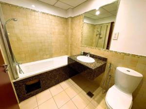 a bathroom with a toilet and a tub and a sink at Entire apartment in JBR Rimal 3 Dubai in Dubai