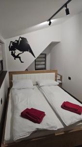 a bedroom with a bed with two red towels on it at Garnet Star Apartments, Kopaonik, apartman br.3. in Kopaonik