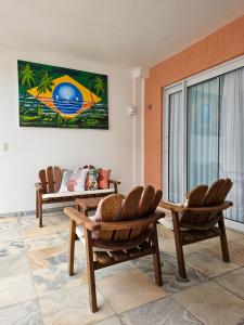 een woonkamer met 2 stoelen en een tafel bij Casa de alto padrão com piscina, ótima para grupos e famílias - a 300m do centro de Pipa in Pipa