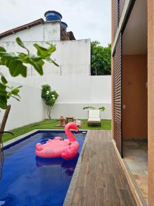 een zwembad met een roze zwaan in een huis bij Casa de alto padrão com piscina, ótima para grupos e famílias - a 300m do centro de Pipa in Pipa