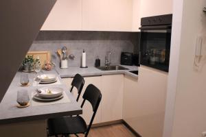 uma cozinha com uma mesa com cadeiras e um lavatório em Dobro došli u Čarne vrhove! em Divčibare