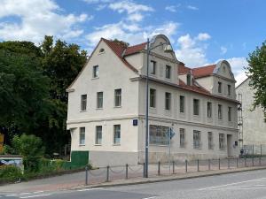 a large white building on the side of a street at Am Fluss Saale in Weißenfels