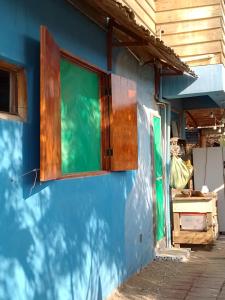 uma parede azul com uma janela do lado de uma casa em Hostal Puerto Engabao Surf Shelter em Engabao
