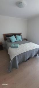 1 dormitorio con 1 cama grande con almohadas azules en Dpto. nuevo una cuadra del lago., en Villarrica