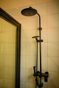um chuveiro na casa de banho com um espelho e uma luz em Pavonah Homes em Kampala