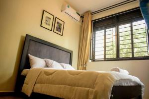 um quarto com uma cama grande e uma janela em Pavonah Homes em Kampala