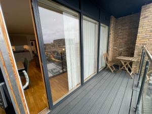 a balcony with sliding glass doors and a table at Lovely 2 Bedroom Apartment London in Woolwich