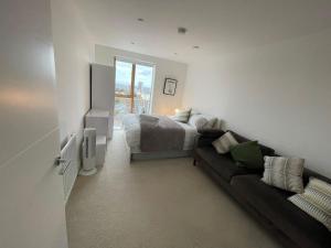 a bedroom with a bed and a couch at Lovely 2 Bedroom Apartment London in Woolwich