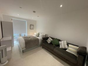 a bedroom with a bed and a couch at Lovely 2 Bedroom Apartment London in Woolwich