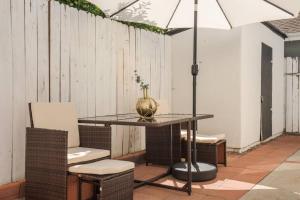 un tavolo con sedie e un ombrellone su un patio di Serene+Yard+Porch&EZ Bike2beach W/D+FreeParking a Signal Hill