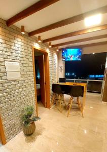 ein Wohnzimmer mit einem Tisch und einem Flachbild-TV in der Unterkunft Salt Beach Residence Inn in Salinópolis