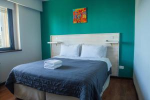 een bed in een kamer met een groene muur bij Hotel BellaVista in Bariloche