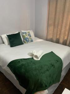 a bed with a green blanket on top of it at 56 Archer Crescent Mainhouse in Durban