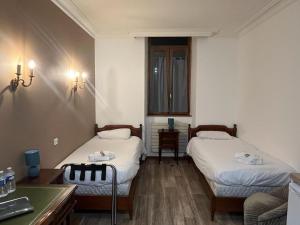 a room with two beds and a table and a desk at Albert 1er in Albertville
