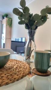 a table with a vase and two cups on it at BOUZAMAR in Vigo