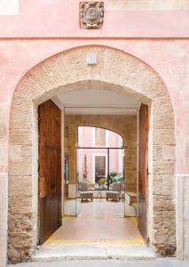 une arche menant à un patio dans un bâtiment rose dans l'établissement Palau Sa Font, à Palma de Majorque