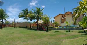 a yard with palm trees and a house at Casa vista mar in Aracaju
