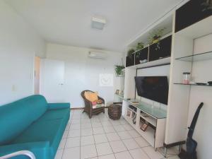 uma sala de estar com um sofá azul e uma televisão em Casa vista mar em Aracaju