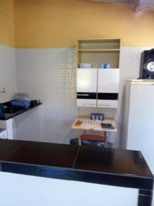 a kitchen with a counter and a table in a room at Meu cantinho in Ubatuba