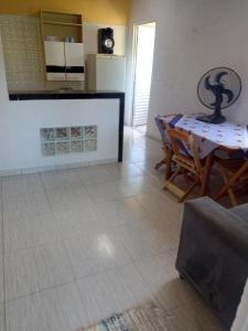 a living room with a table and a kitchen at Meu cantinho in Ubatuba
