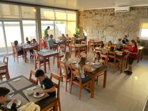 un grupo de personas sentadas en mesas en un restaurante en JP HOUSE en Nelas