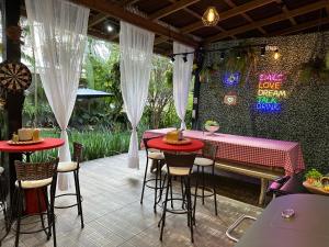 un restaurante con mesas rojas y taburetes en un patio en UFSC Guest House, en Florianópolis