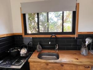 a kitchen sink with a window above a stove at Studio Cabin I in José Ignacio
