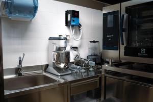 a kitchen with a mixer next to a sink at Hostelò - Luxury Hostel in Palermo
