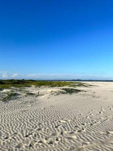 uma praia arenosa com um céu azul ao fundo em Casa praia pontal e ilha do mel em Pontal do Paraná