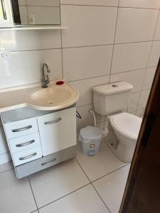 uma casa de banho branca com um lavatório e um WC em Casa praia pontal e ilha do mel em Pontal do Paraná