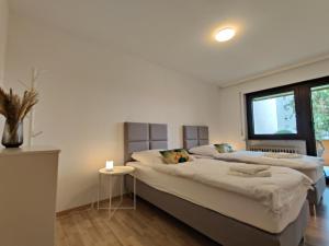 a bedroom with two beds and a window at 81qm, 3 bedroom, King-Bed, parking, fast Wifi, Netflix in Waiblingen