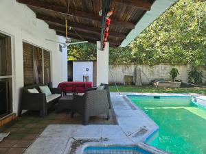 a patio with a table and chairs next to a swimming pool at CHALET EN PUERTO VIEJO IZTAPA in Escuintla