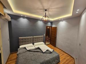 een slaapkamer met een groot bed en een kroonluchter bij 3rd floor luxury apartment-families only in Alexandrië