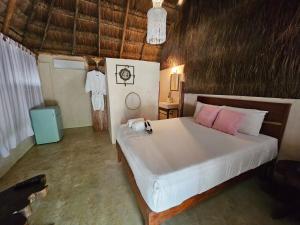 1 dormitorio con 1 cama blanca grande con almohadas rosas en Hotel Kin Tulum Jungle Deluxe, en Tulum