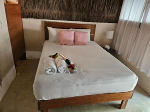 Una cama con dos muñecas y toallas. en Hotel Kin Tulum Jungle Deluxe, en Tulum