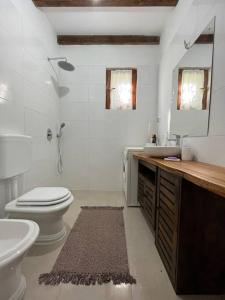 Baño blanco con aseo y lavamanos en “House Botić”, 