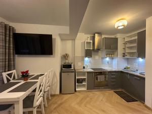 コシチェリスコにあるApartament Skandynawska Prostota z basenem i saunąのキッチン(テーブル付)、ダイニングルーム