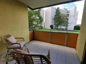 a balcony with chairs and a view of a building at 81qm, 3 bedroom, King-Bed, parking, fast Wifi, Netflix in Waiblingen