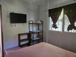 a bedroom with a bed and a flat screen tv at CHALET EN PUERTO VIEJO IZTAPA in Escuintla