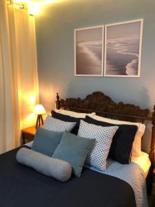 a bedroom with a bed with blue and white pillows at Suíte Verão na Praia in Cabo Frio