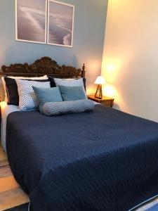 een slaapkamer met een groot bed met blauwe lakens bij Suíte Verão na Praia in Cabo Frio